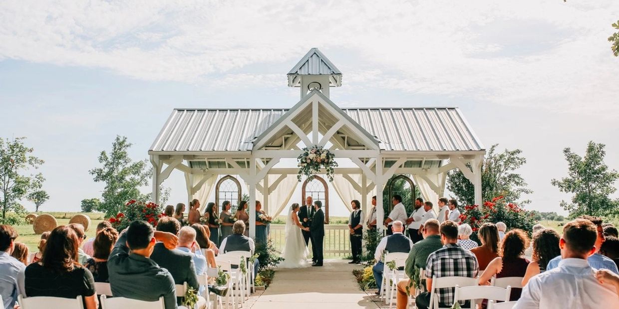 Outdoor wedding ceremony under a white pavilion.