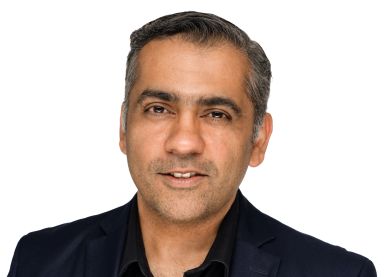 Portrait of a middle-aged man wearing a black blazer against a white background.