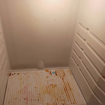 Refrigerator interior before cleaning with food stains and residue.