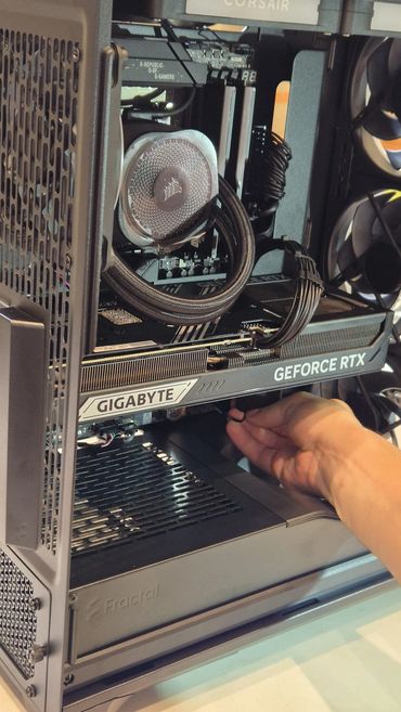 Hand installing a Gigabyte GeForce RTX graphics card in a Fractal PC case.