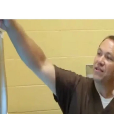 Man in scrubs explaining something on an X-ray to a woman.