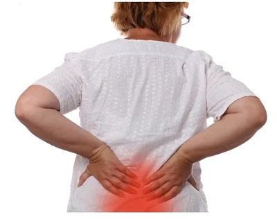 Person holding lower back in pain, highlighting discomfort.
