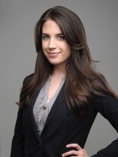 Headshot of Attorney Brittany N. Hernandez smiling and wearing a suit with her hand on her hip.