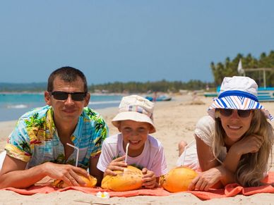 A family enjoying fresh coconut drinks on a sunny beach.