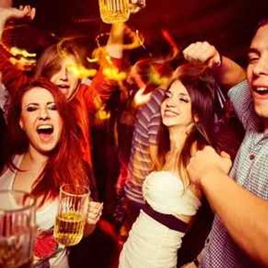 People enjoying a lively night out with drinks and dancing.