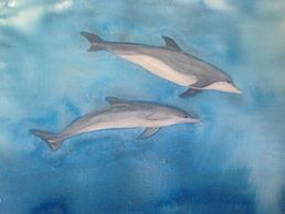 Watercolor painting of two dolphins swimming in blue water