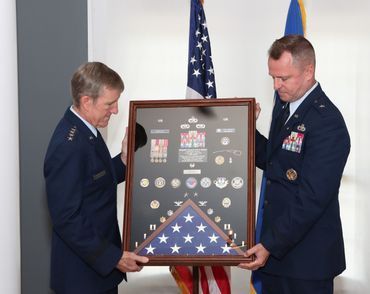 Retired General "Hawk" Carlisle presents Brigadier General Carl "Ferris" Buhler his Shadow Box.