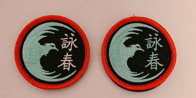 Two circular embroidered patches with bird and Asian characters.