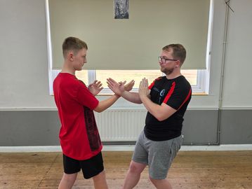 Teenager learning practicing martial arts indoors.