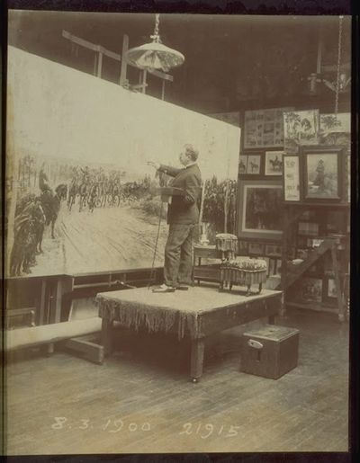 Artist working on a large painting in a studio.