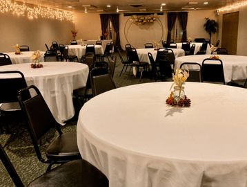 Empty banquet room with round tables and chairs.