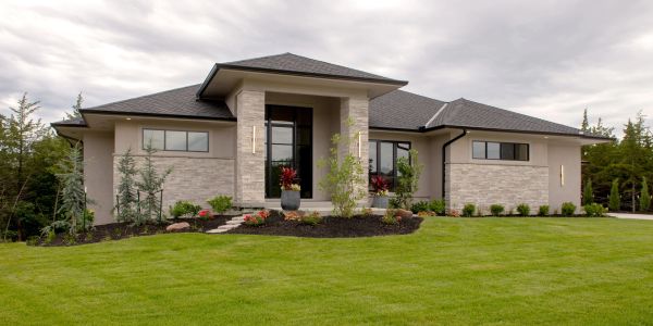 Modern single-story house with lush green lawn.