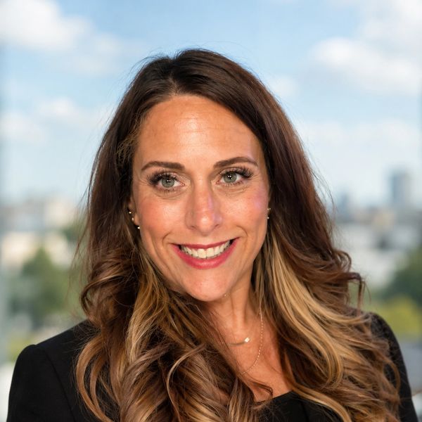 Smiling woman with long brown hair and light highlights.