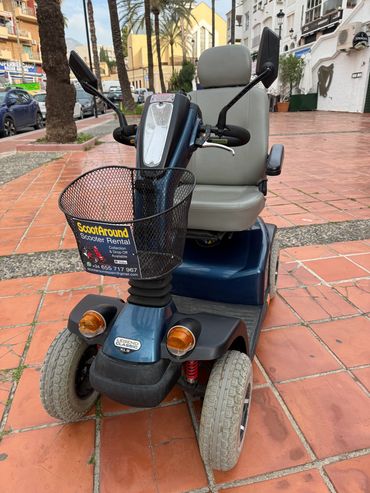 Blue mobility scooter with a front basket for rental in a city setting.