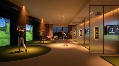 Indoor golf simulation room with multiple players and screens.