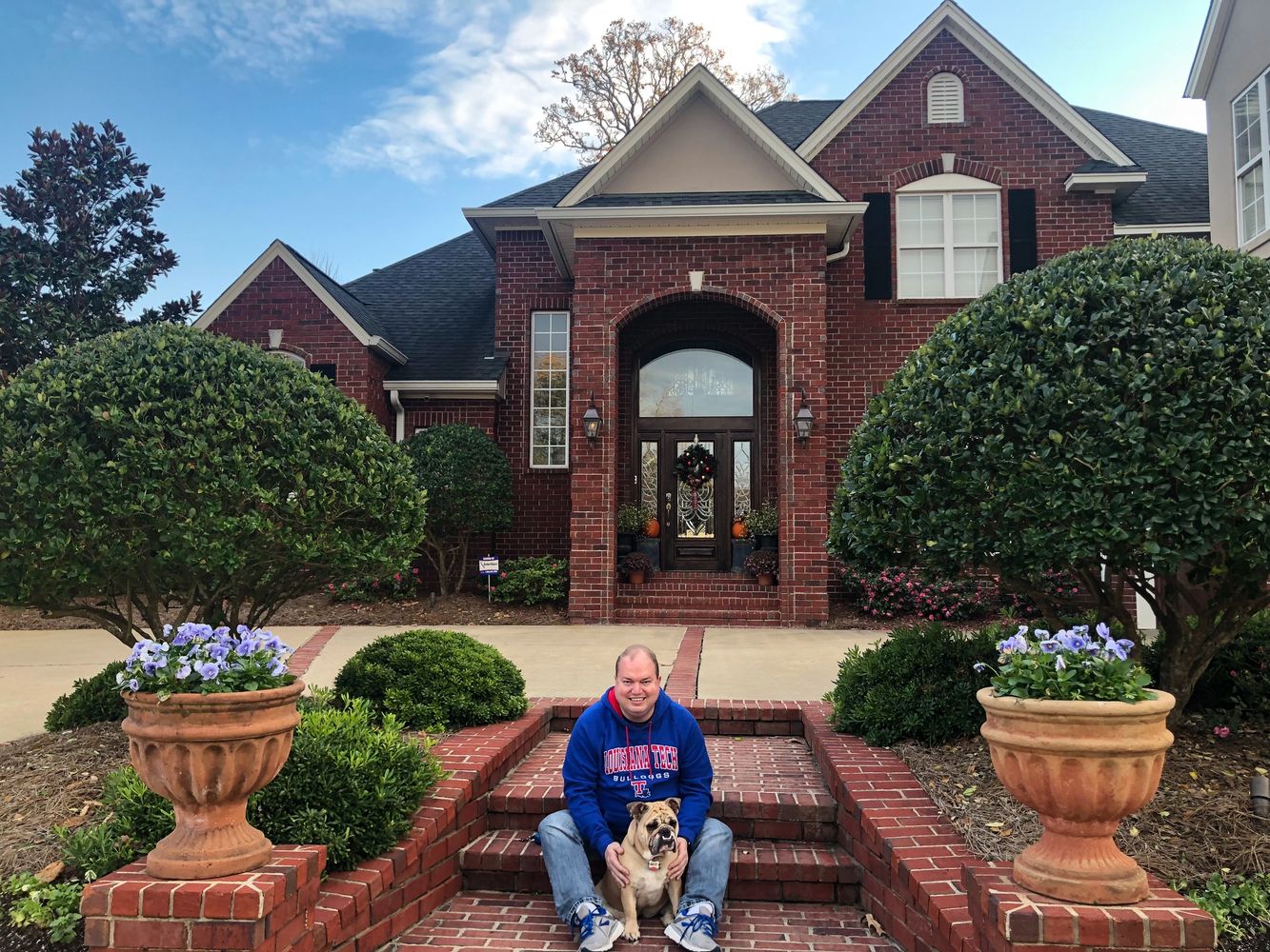 Brandon in front of his home with his bulldog and partner in crime, Praline.