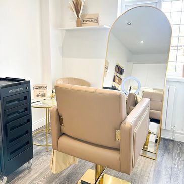 Modern beauty salon chair with a large mirror and sleek decor.