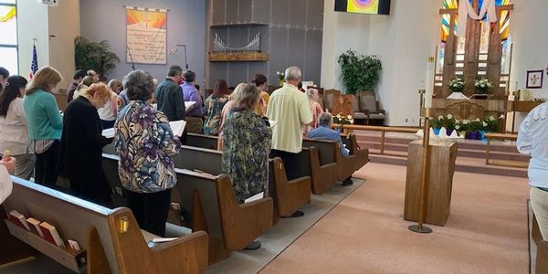 a group of people standing in front of pews in a church