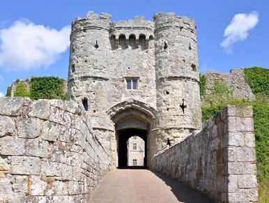 Ancient stone castle entrance with towers and a path.