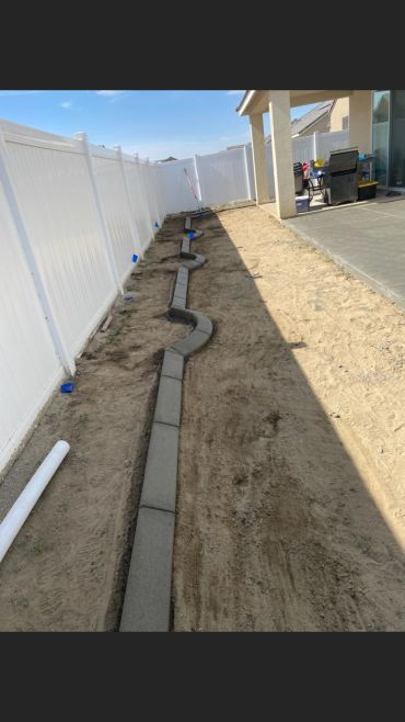 Caminos de adoquines serpenteando un jardín en construcción.