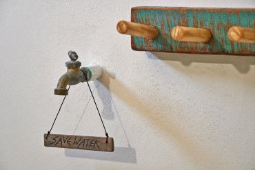 Vattenkran med skylt som säger "Save Water".
