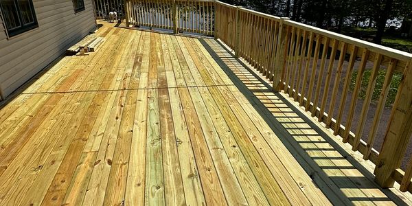 A newly built wooden deck with railings on a sunny day.