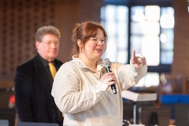 Jordy Novak speaking into a microphone and pointing.