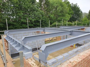Steel beams installed on a brick foundation for building construction.