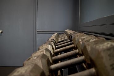 Imagen de estante con pesas que usa con manos.