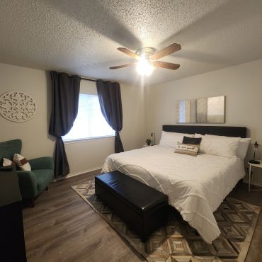 Cozy bedroom with white bedding and dark curtains.
