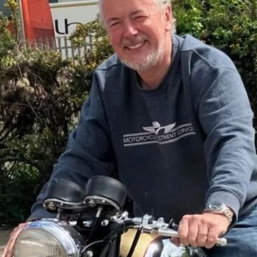 Man smiling while sitting on a motorcycle.