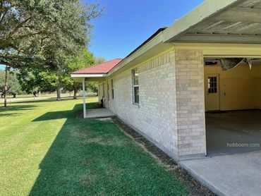 looking down the front of the house with the garage door open.