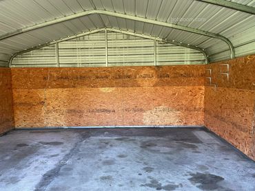 View inside a metal building lined with chipboard.
