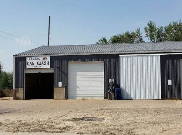 IMAGE OF DARK GRAY BUILDING WITH 2 CLOSED WHITE GARAGE DOORS AND ONE OPEN GARGAE BAY WITH CHARLOTTE