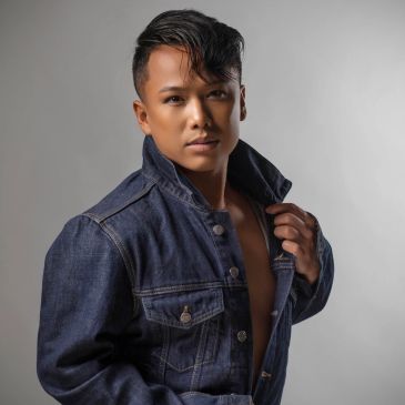 Confident man posing in a denim jacket.