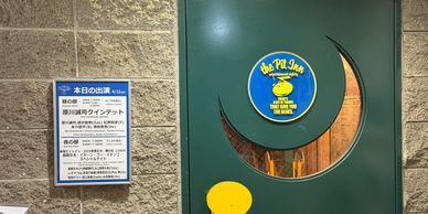 A green door with a Peanuts-themed sign and a schedule on the wall.