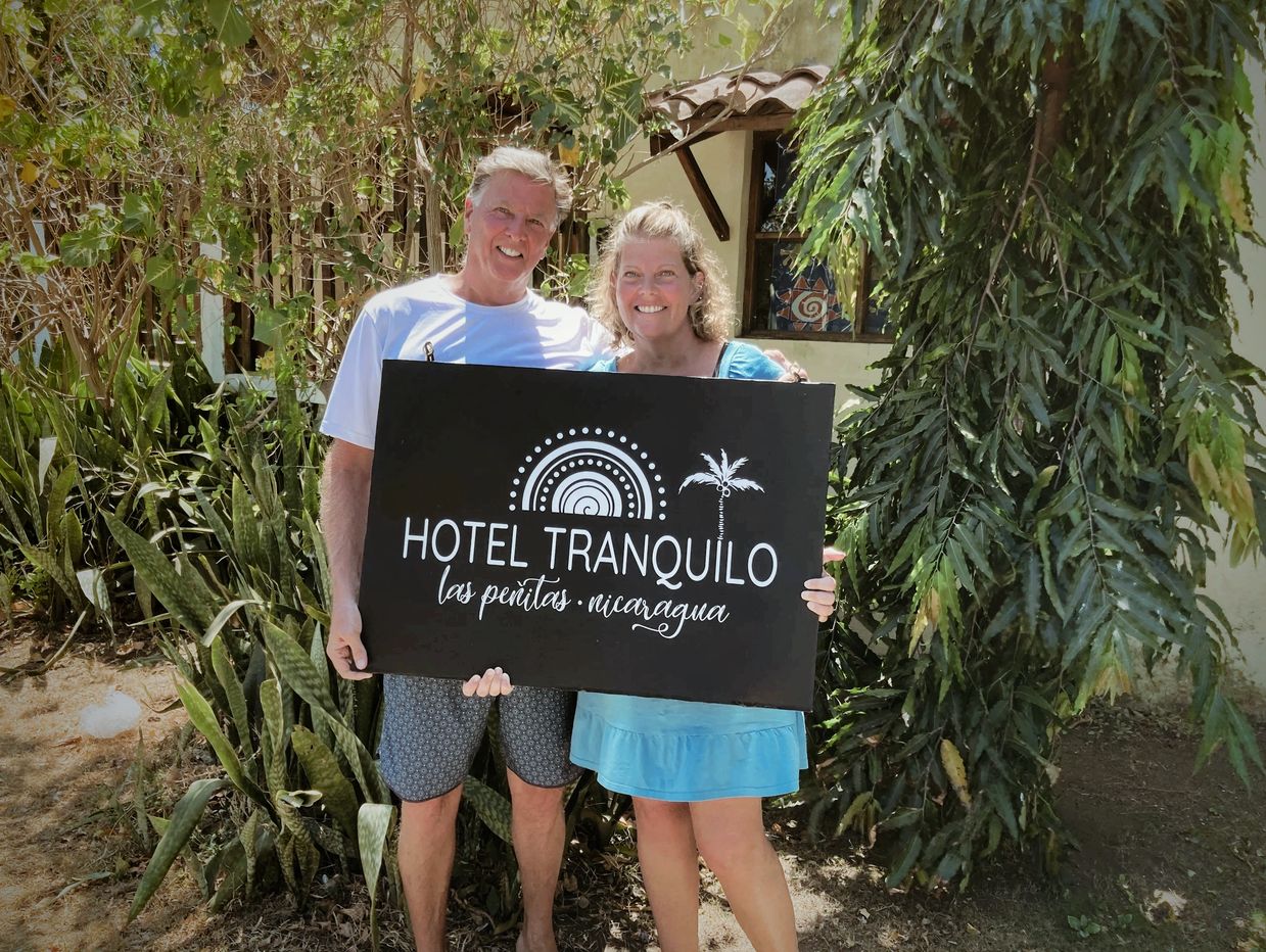 Jack and Carmen Shields holding the Hotel Tranquilo sign