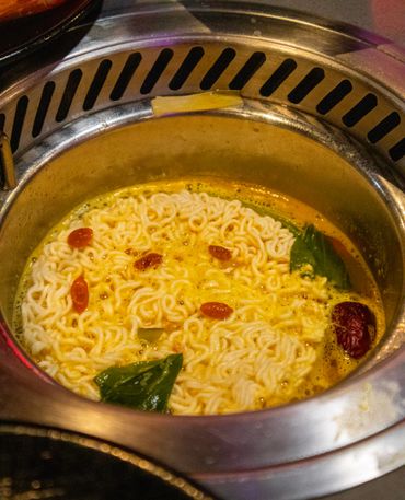 ramen in a hot pot on a table