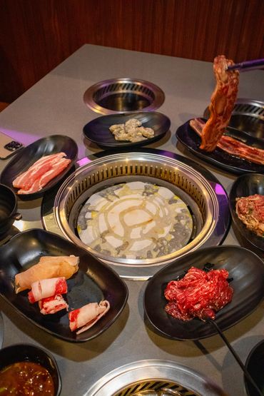 table full of korean bbq meat with grill