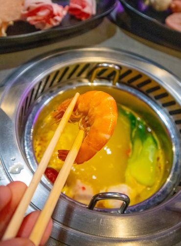 chopsticks holding a cooked shrimp