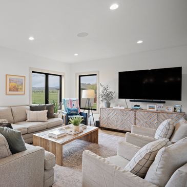 Bright and cozy living room with neutral tones and large TV.