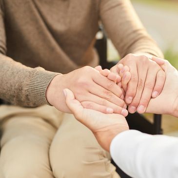 Two people holding hands in a gesture of support