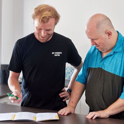 Support worker and client looking through papers in the kitchen