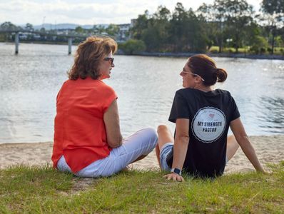 Support worker and client sitting on the grass talking