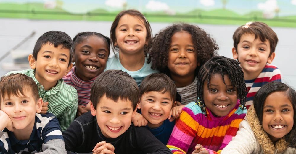 A diverse group of happy children smiling and posing together indoors.