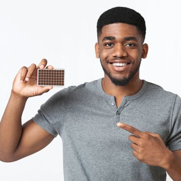 Man holding flesh colored ear seeds kit.