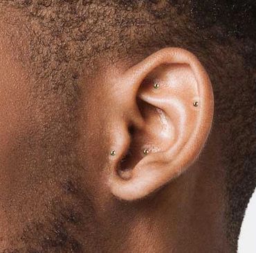 Gold ear seeds on a man's ear.