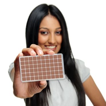 Woman holding flesh colored ear seeds.