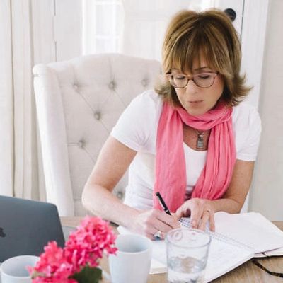woman working at desk with laptop and binder