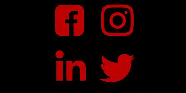 Red social media icons for Facebook, Instagram, LinkedIn, and Twitter on black.